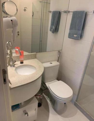 uma casa de banho com um WC, um lavatório e um espelho. em FLATS VISION em Brasília