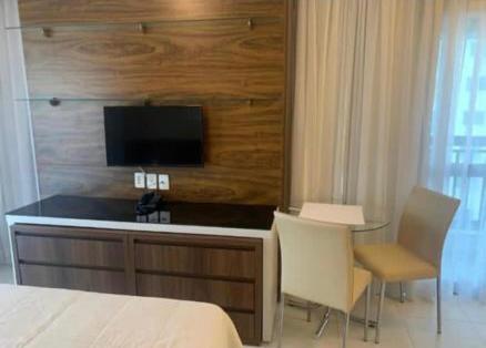 um quarto com uma cama e uma secretária com uma televisão em FLATS VISION em Brasília
