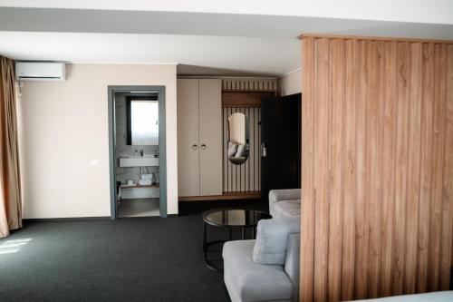 a room with a couch and a chair and a table at River Park Hotel in Drăgăşani