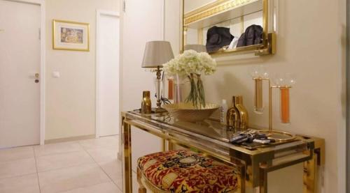 Una habitación con una mesa con un jarrón de flores. en Luxury Diplomat-Penthouse - UNO City Vienna en Viena