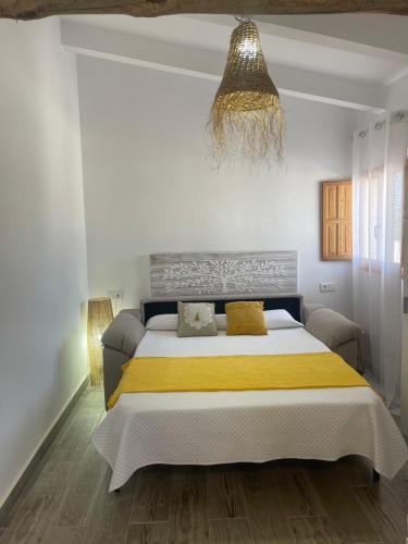 sypialnia z dużym łóżkiem i żyrandolem w obiekcie Finca el Atardecer-Luna w mieście Los Santos de Maimona
