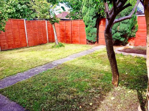 a yard with an orange fence and a tree at The Washington Sleeps 10 people park 4 cars in Bristol