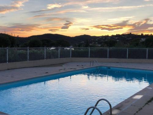 une piscine bleue avec un coucher de soleil en arrière-plan dans l'établissement Agay bay see front, à Saint-Raphaël