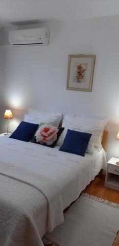 a white bed with blue pillows in a bedroom at Apartment Villa Green Court in Korčula