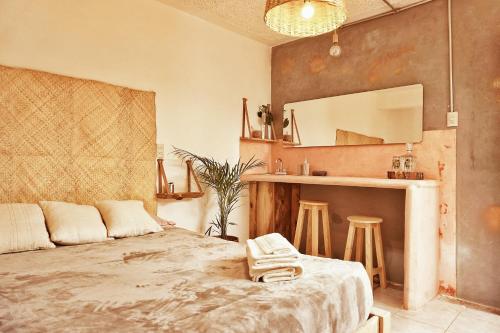 a bedroom with a bed and a mirror and stools at Hostel Boutique 55 in San Cristóbal de Las Casas