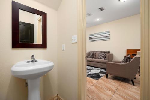 baño con lavabo, silla y sofá en Hummingbird Haven 2 Cozy Comfort Haven - Parking at No Extra Cost, en Pharr