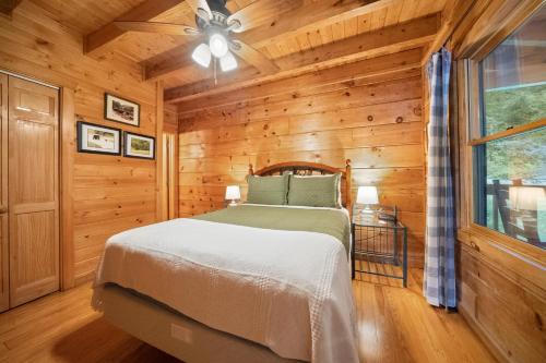 Un dormitorio con una cama en una cabaña de troncos en Baloo's Bungalow, en Gatlinburg