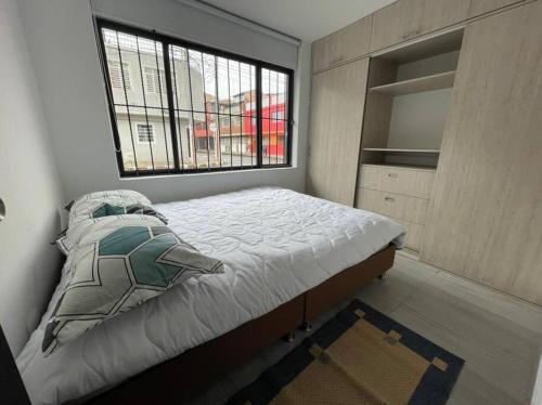 a bedroom with a large bed and a window at Apartamento Acogedor y muy central en Bogotá in Bogotá