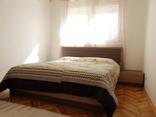 - un lit dans une chambre avec fenêtre dans l'établissement Ljupki apartman 2 km od centra i besplatan parking, à Podgorica