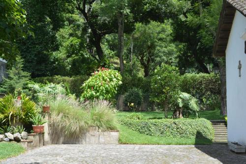un jardín con plantas y árboles y un camino en Casa San Miguel, en Antigua Guatemala