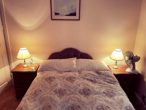 1 dormitorio con 1 cama con 2 mesitas de noche y 2 lámparas en God’s Abode, en Windsor