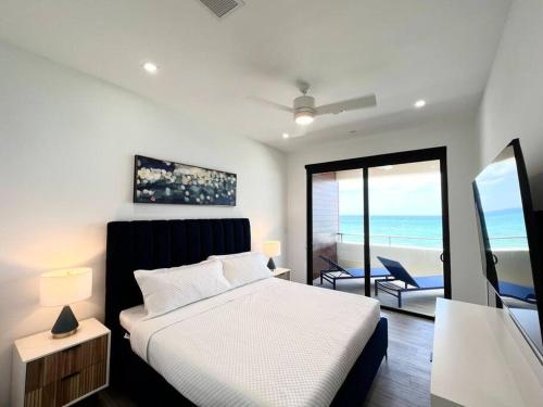 a bedroom with a bed and a view of the ocean at Luxury Ocean front SeaDreams 2 with 7 Mile Beach Views in West Bay