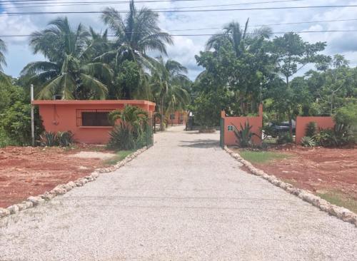 a road leading to a house with palm trees at Hotel Bacalar Sunshine in Bacalar