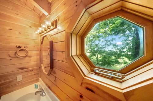 baño en una casa del árbol con ventana en Baloo's Bungalow, en Gatlinburg