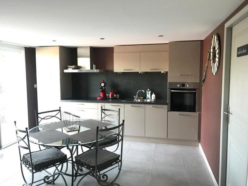 a kitchen with a table and chairs in a room at Les Balusets in Vinezac