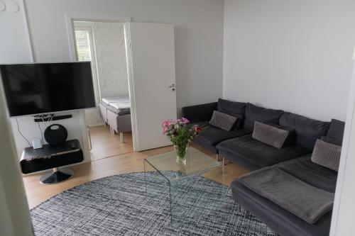 a living room with a couch and a glass table at Villa Rajaportti 1st&2nd floor Loft with lakeview and free front door parking with electric car plug in Tampere