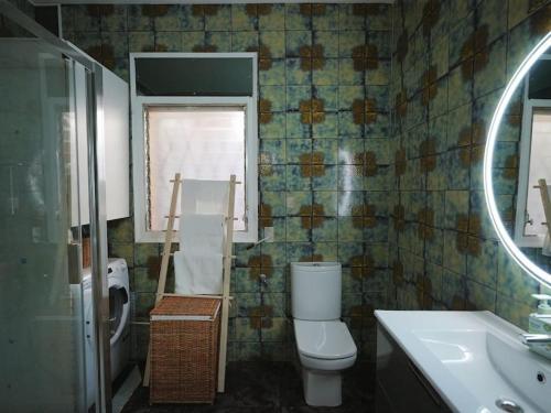 ein Badezimmer mit einem WC, einem Waschbecken und einem Spiegel in der Unterkunft A+View Private Terrace Private Pool Family Fun in Badalona