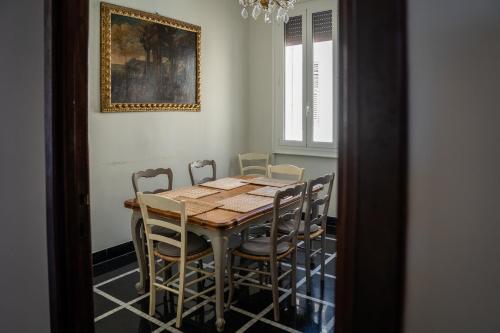 una mesa de comedor con sillas y una pintura en la pared en The Chandelier, en Génova