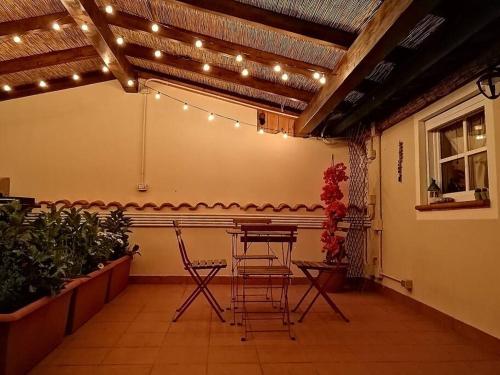 a patio with a table and chairs and lights at CASA LITA con terrazzo in Ravenna