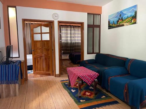 a living room with a blue couch and a table at Villas JABEL TINAMIT in Panajachel