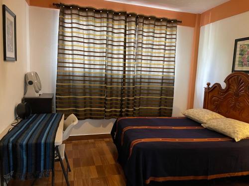 a bedroom with two beds and a window at Villas JABEL TINAMIT in Panajachel