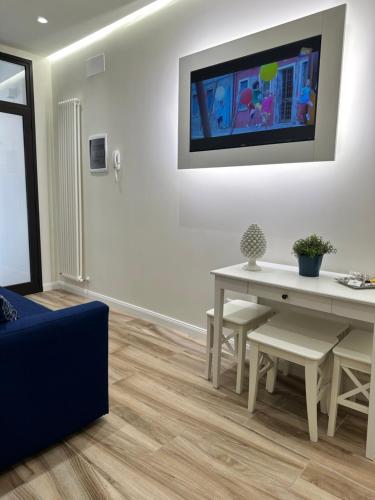 sala de estar con mesa y TV en la pared en Ines bed and breakfast & Apartments, en Giardini Naxos