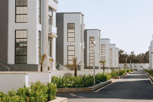 a row of white apartment buildings with plants at Buzovna Villas in Buzovna