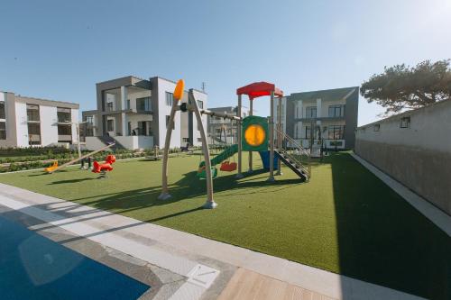 a playground with children playing on the grass at Buzovna Villas in Buzovna