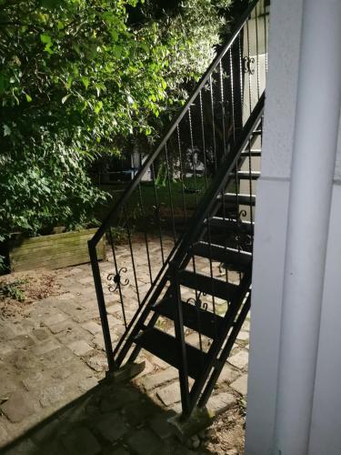 a black metal stair railing next to a building at Bleu studio jaccuzi appart in Sevran