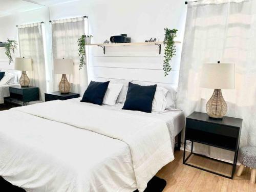 a bedroom with a large white bed and two lamps at Beautiful Bright Condo Steps Away from the Beach in Long Beach