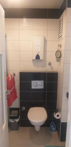 a small bathroom with a toilet and a red towel at Sunset Beach Resort, 5* hotel/beach facilities in Alanya