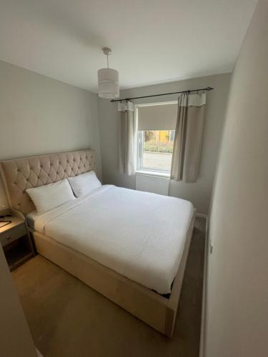 a bedroom with a white bed and a window at The Retreat at Harlow in Potter Street