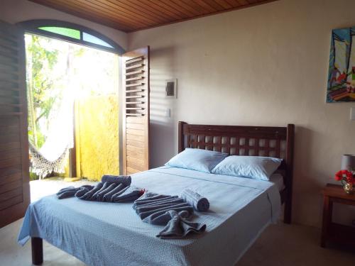1 dormitorio con 1 cama con toallas en Casa Manhapeba, en Isla de Boipeba
