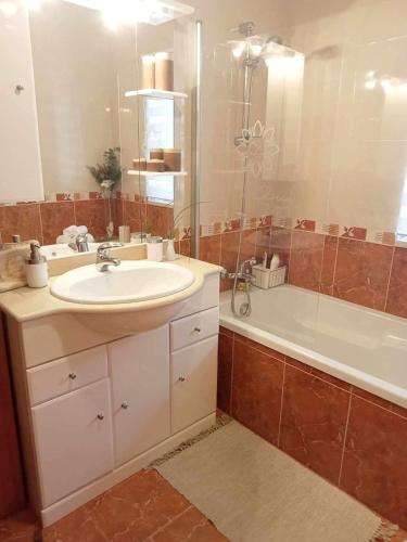 a bathroom with a sink and a tub and a mirror at Casa Gloria in Paço Vedro de Magalhães