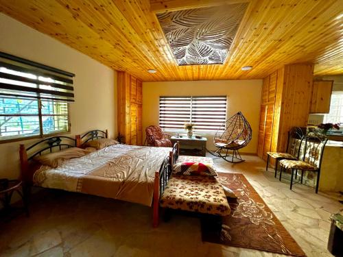 1 dormitorio con 1 cama grande y techo de madera en Oak Farm مزرعة الملّول en Ajloun