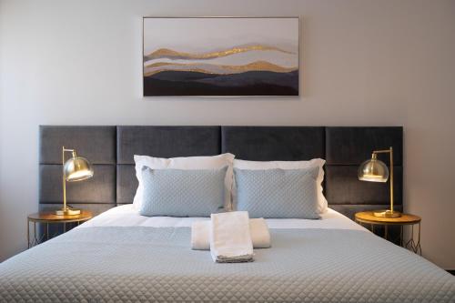 a bedroom with a large bed with two lamps at Home Essences in Porto