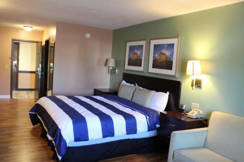 a hotel room with a bed and a chair at Bellevue Hotel and Suites in Bellevue