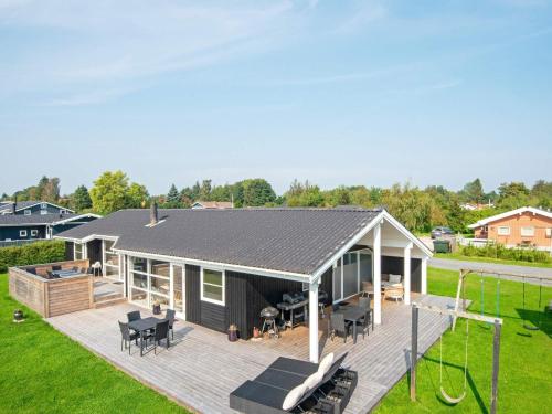 a house with a large deck with a backyard at 10 person holiday home in Juelsminde in Sønderby