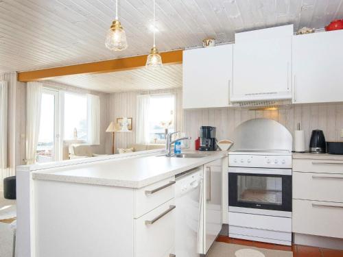 a kitchen with white cabinets and a stove top oven at 6 person holiday home in Juelsminde in Sønderby