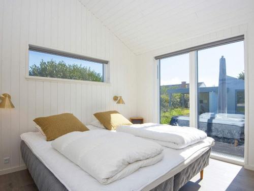Duas camas num quarto com uma janela grande em Holiday home Juelsminde XLIII em Juelsminde