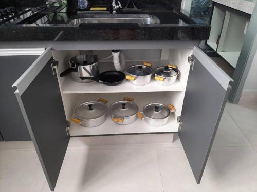a kitchen counter with pots and pans and a sink at Luxo e conforto in Goiânia