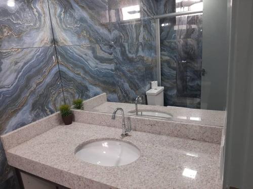 a bathroom with a sink and a granite wall at Luxo e conforto in Goiânia