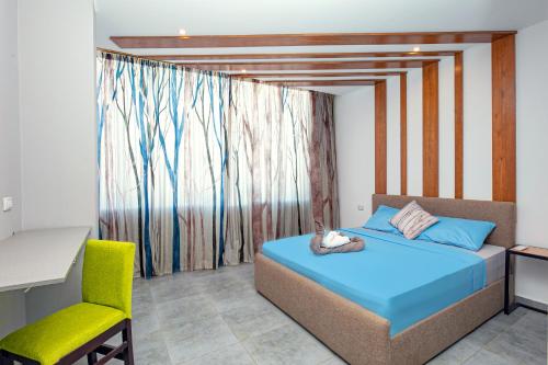a bedroom with a bed and a chair and a window at Bedcoin Hostel in Hurghada