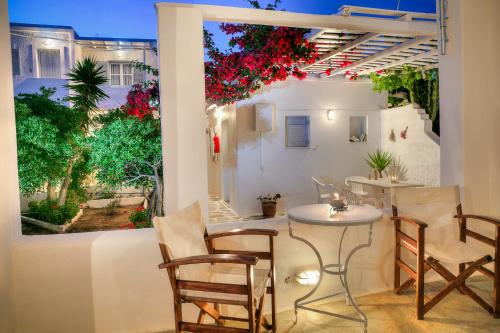 a patio with a table and chairs and a window at Paros Rita Studios in Piso Livadi