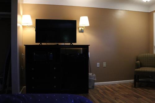 a bedroom with a flat screen tv on a dresser at Bellevue Hotel and Suites in Bellevue
