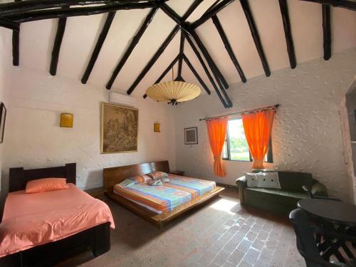 ein Schlafzimmer mit einem Bett und einem Sofa in einem Zimmer in der Unterkunft CASA CAMPESTRE LA CAMPIÑA LA VICTORIA Valle del Cauca ESPACIO COMPLETO-desayuno a pareja in Matazarza