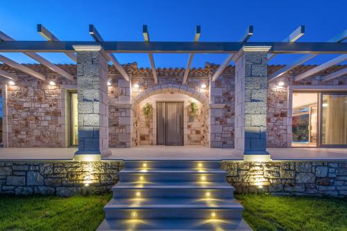 a house with a pathway to the front door at night at Avra Luxury Villa & Spa in Keri