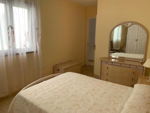 1 dormitorio con 1 cama grande y espejo en Apartamento San Telmo, en Puerto de la Cruz