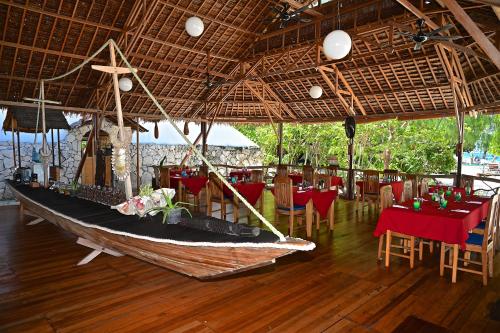 a restaurant with a boat in the middle of a room at Agusta Eco Resort in Pulau Mansuar