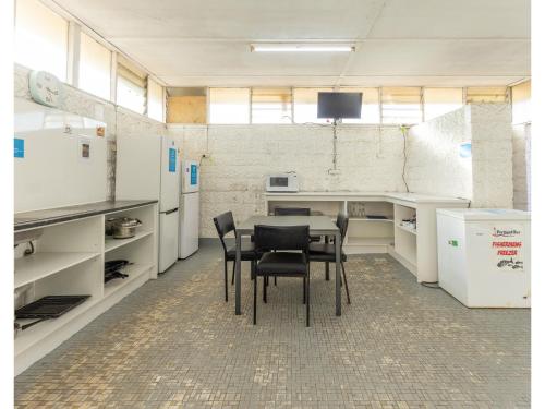 a kitchen with a table and chairs in a room at NRMA Portland Bay Holiday Park in Portland